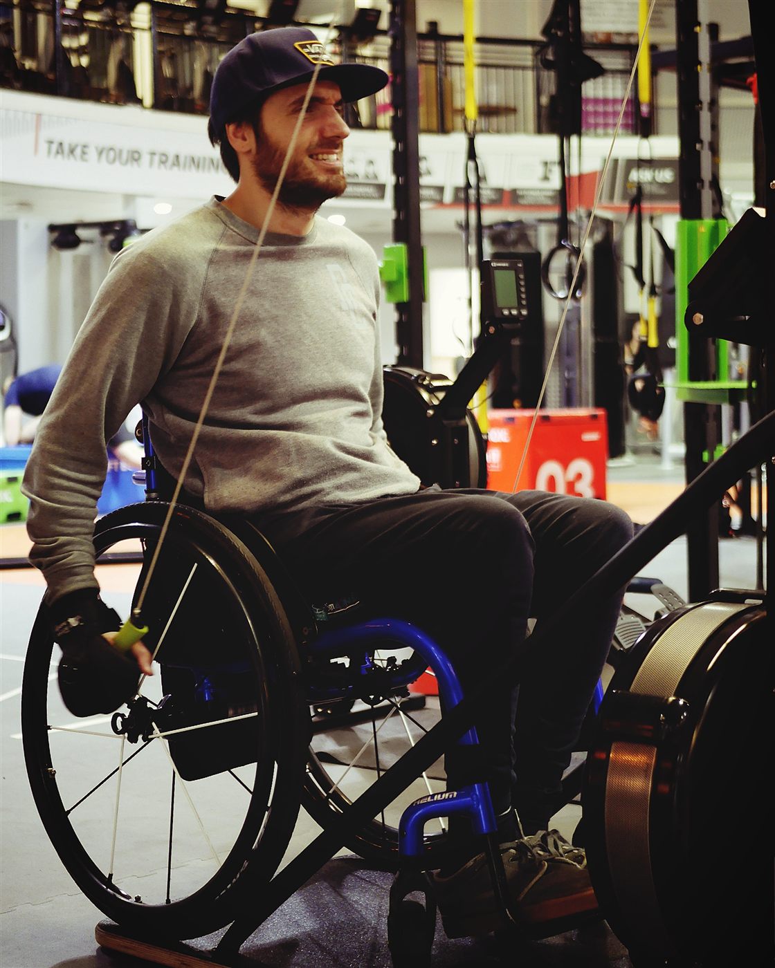 Persona en silla de ruedas entrenando en el gimnasio con agarre adaptativo Active Hands. Garra Adaptive Argentina.